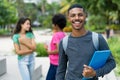 Smart african american male student with group of brazilian female young adults Royalty Free Stock Photo