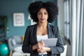 Smart afro young entrepreneur woman using her digital tablet while standing looking at camera in the office at home Royalty Free Stock Photo
