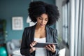 Smart afro young entrepreneur woman using her digital tablet while standing in the office at home Royalty Free Stock Photo