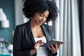 Smart afro young entrepreneur woman using her digital tablet while standing in the office at home Royalty Free Stock Photo