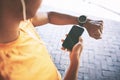 The smart app that gets you sweating. a man pairing his watch with a smartphone during a workout against an urban