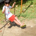 Smart Asian boy riding on swing in society park, happy boy play outdoors in summer, baby boy playing swing in the garden Royalty Free Stock Photo