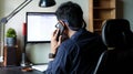 Smart Asian businessman talking on mobile phone and working with laptop computer Royalty Free Stock Photo