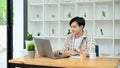 Smart Asian man or male freelancer using laptop, working in the office