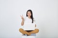 Woman sitting using laptop sitting on gray background Royalty Free Stock Photo