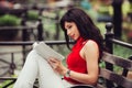 Smart beautiful woman reading a book sitting on the bench in the park.