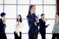 Smart and beautiful young Asian businesswoman with black long hair in suit talking on mobile phone at the window office workplace Royalty Free Stock Photo