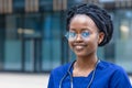 Black girl medical student in glasses, happy young african american woman doctor in blue uniform, stethoscope, Royalty Free Stock Photo