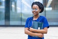 Smart black girl medical student in glasses, happy young african american woman doctor in blue uniform, stethoscope, Royalty Free Stock Photo