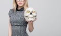 Smart blonde woman showing skull with bitcoins in eyes concept
