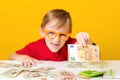 Smart boy in glasses with money cash. Kid thinking where to invest money. Happy kid counting money. Business and finance concept Royalty Free Stock Photo