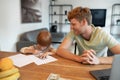 Little boy drawing a dollar sign , his ftaher watching