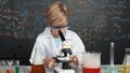 Smart boy using microscope analysis sample at science laboratory. Erudition. Royalty Free Stock Photo