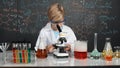 Smart boy using microscope analysis sample at science laboratory. Erudition. Royalty Free Stock Photo