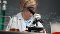 Smart boy using microscope analysis sample at science laboratory. Erudition. Royalty Free Stock Photo