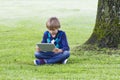 Smart boy using a tablet outdoors. Technology, lifestyle, education, people concept Royalty Free Stock Photo