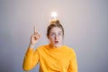 Smart business idea concept. Teenager student girl in glasses raising index finger looking up having bright idea or plan. Royalty Free Stock Photo