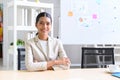 Smart business woman sits at desk in office. portrait happy businesswoman looking at the camera sitting at office table Royalty Free Stock Photo