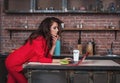 Smart business woman working on her laptop at home in kitchen