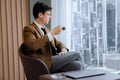 Smart businessman holding coffee cup while looking skyscraper view. Ornamented. Royalty Free Stock Photo