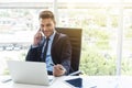 Smart businessman using mobile and laptop in office Royalty Free Stock Photo