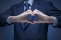 Handsome man show heart symbol, love icon for Business lover, I love my job, take care service concept. Smart Businessman wear