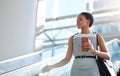 Smart businesswomen stay on the move. an attractive young businesswoman taking an escalator in a modern workplace.