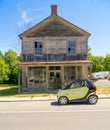 Smart Car in front of old wooden house. Royalty Free Stock Photo