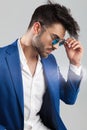 Smart casual man fixing his sunglasses looks down to side Royalty Free Stock Photo