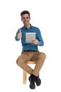 Smart casual man making thumbs up sign and holding tab Royalty Free Stock Photo