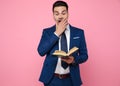 Smart casual man reading a book on pink background Royalty Free Stock Photo