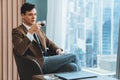 Smart businessman holding coffee cup while looking skyscraper view. Ornamented. Royalty Free Stock Photo