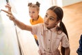 Smart caucasian girl using interactive whiteboard with her finger Royalty Free Stock Photo