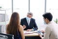 Smart Caucasian senior manager and businessman in black suit talking with asian teamwork staff is wearing masks prevent covid 19