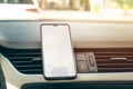 Smart cell phone in the center car console with white blank screen Royalty Free Stock Photo