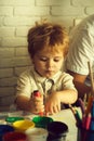 Smart child draws. Creative baby. Serious boy draws. Young artist creates picture with pink felt-tip pen and paints