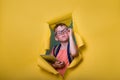 Smart child in glasses holding laptop computer tablet and breaking through yellow paper wall. Back to school. Student Royalty Free Stock Photo