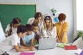 Smart children pupil boys and girls stand in front of laptop with woman teacher in primary school Royalty Free Stock Photo