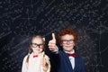 Smart children school student in glasses having fun on background with science and maths formulas