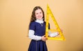 Smart and clever concept. Girl with big ruler. School student study geometry. Sizing and measuring. Kid school uniform Royalty Free Stock Photo