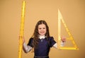 Smart and clever concept. Sizing and measuring. Pupil cute girl with big ruler. School student study geometry. Kid Royalty Free Stock Photo