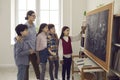 Elementary school girl student answering at board on lesson front of classmates