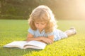 Smart clever Kids. Beautiful child boy book on grass background. Kids reading book in park. Royalty Free Stock Photo