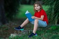 Smart clever Kids. Cute child read books outdoors. Kids learning and summer education. Child boy reading book outdoor on Royalty Free Stock Photo