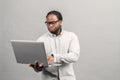 Smart African-American man using a laptop, isolated on grey Royalty Free Stock Photo