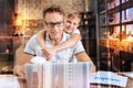 Smart concentrated man looking at the computer while his son hugging him Royalty Free Stock Photo