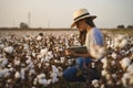 Smart cotton farmer checks the cotton field with tablet.