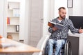 Smart disabled guy spending his free time studying Royalty Free Stock Photo