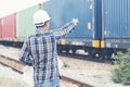 Smart engineer holding white hard hat on hand and look at refinery industry plant at industry factory center area. Asian man