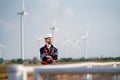 Smart engineer or technician man stand with arm crossed and look to right side with background of windmill or wind turbine and